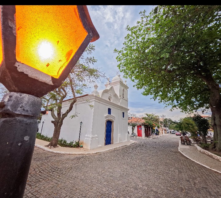 Igreja e rua histórica de Cabo Frio com um lampião em primeiro plano